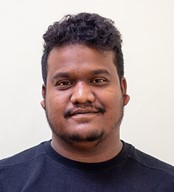 Head shot of a smiling Nepali man with a moustache