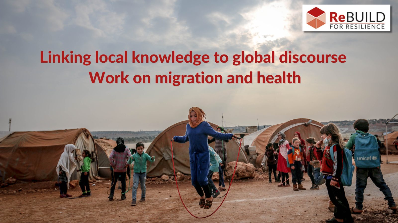 It's a refugee camp. Children are playing next to tents. the ground is muddy and one child has a UNICEF rucksack. And the text 'Linking local knowledge to global discourse: Work on migration and health'